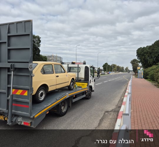 רכב ישן על גרר בכביש פתוח